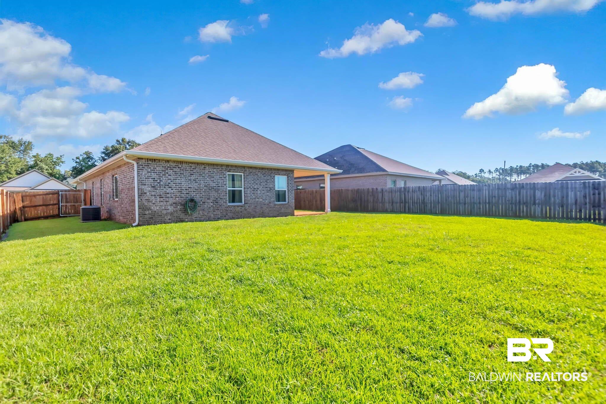 16461 Prado Loop Loxley, AL 36551 - Photo 61 of 78 Rear view of house with a fenced backyard, brick siding, and a shingled roof