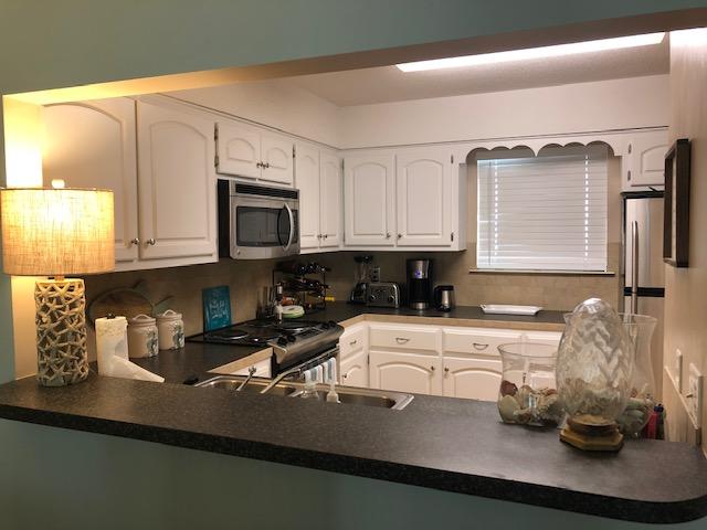 63 Sandy Lane, Unit 102 Santa Rosa Beach, FL 32459 - Photo 13 of 26 a kitchen with a sink a stove and cabinets