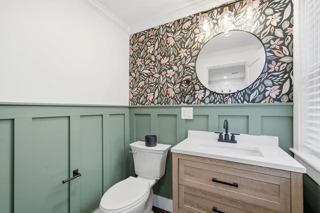 a bathroom with a sink mirror vanity and toilet