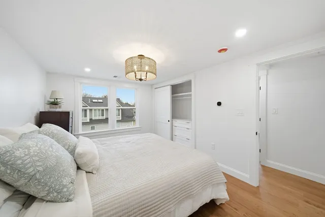 a bedroom with a large bed and a chandelier