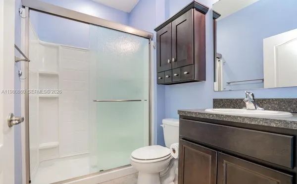 a bathroom with a granite countertop sink toilet and shower