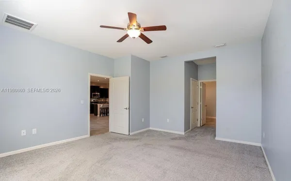 a view of a livingroom with a ceiling fan & entryway
