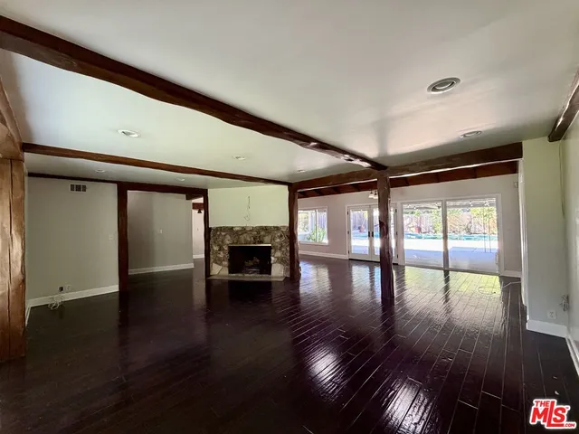 a view of empty room with wooden floor and fireplace
