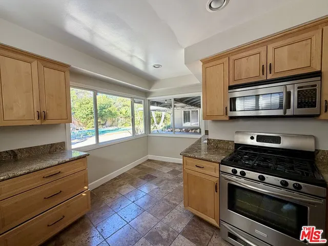 a kitchen with stainless steel appliances granite countertop a stove and cabinets