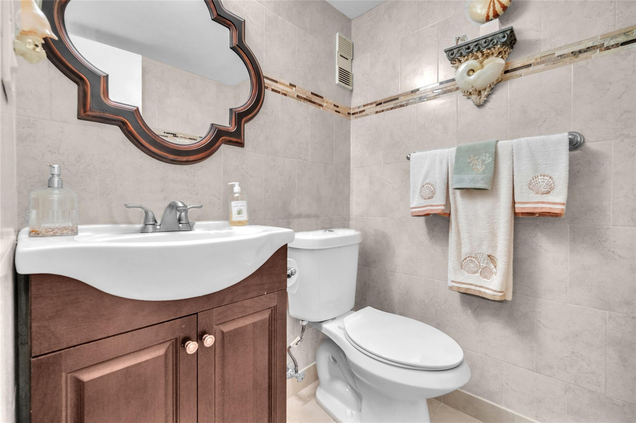 3910 Inverrary Boulevard, Unit 308B Lauderhill, FL 33319 - Photo 14 of 53 a bathroom with a sink a toilet and a mirror