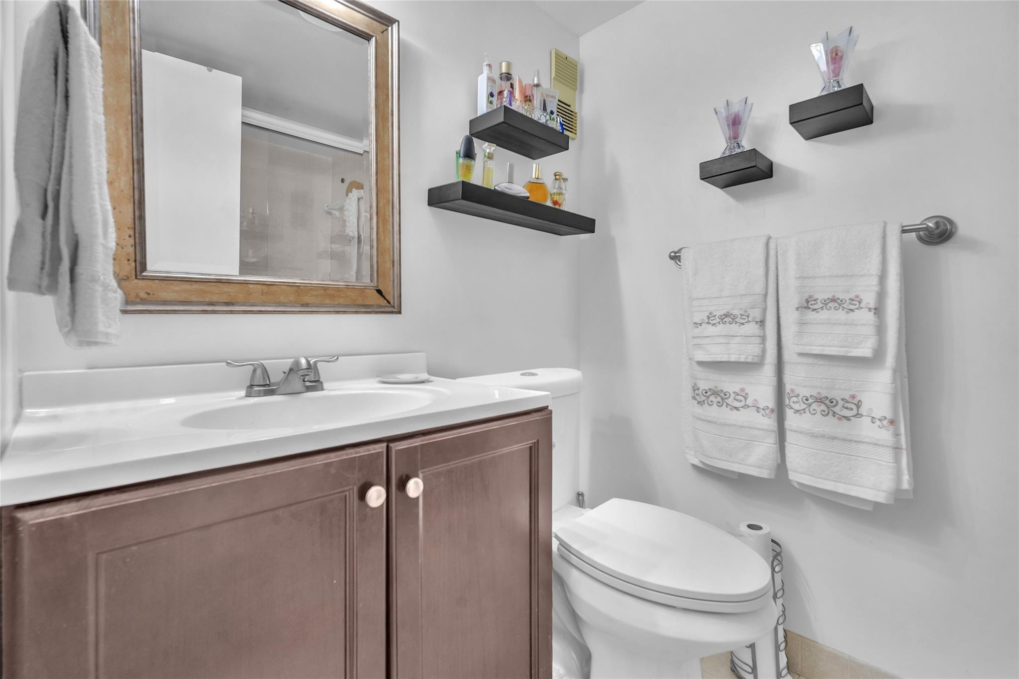 3910 Inverrary Boulevard, Unit 308B Lauderhill, FL 33319 - Photo 19 of 53 a bathroom with a granite countertop sink a toilet and a mirror
