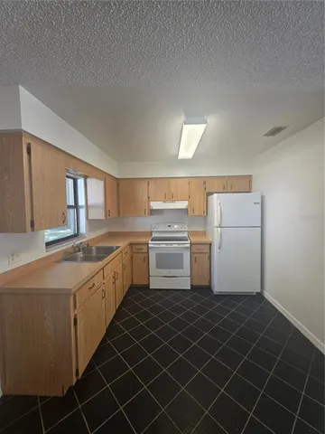 a kitchen with a sink a stove and cabinets