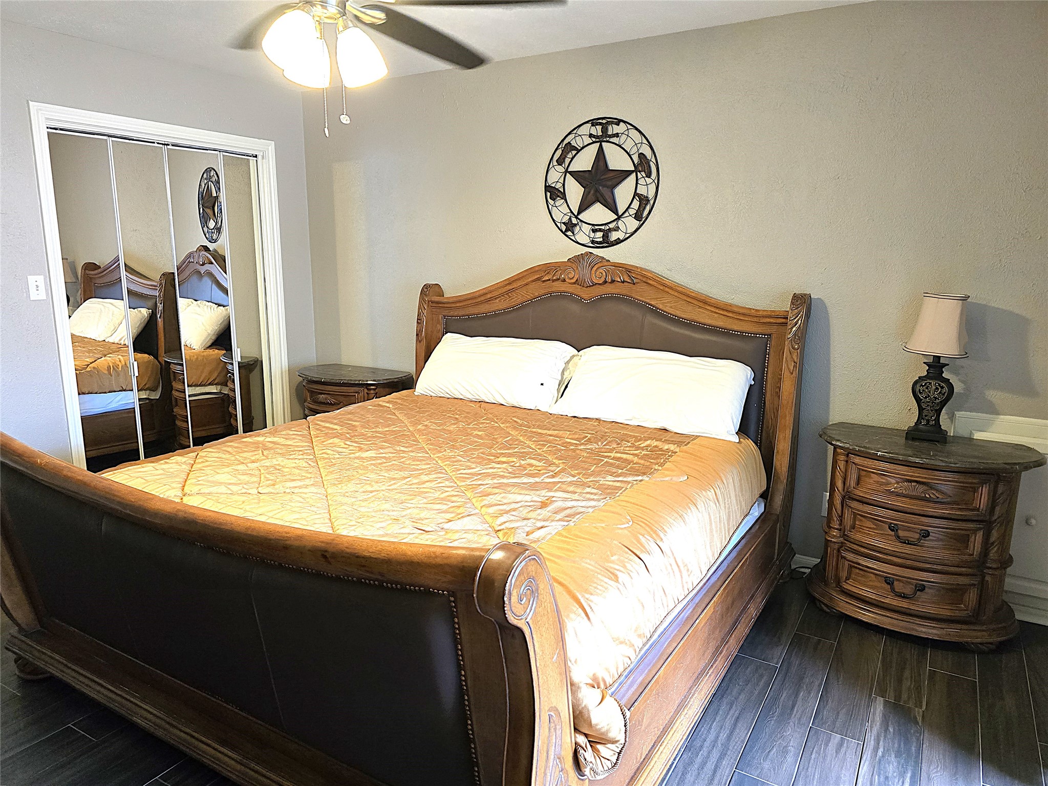 560 Brandon Road Conroe, TX 77302 - Photo 36 of 45 Cozy third bedroom featuring elegant wood flooring, a stylish bed, and ample storage with mirrored closet doors. Perfect for relaxation or guests.