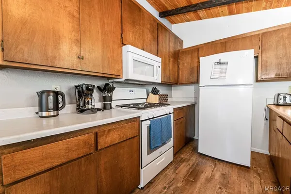 a kitchen with stainless steel appliances granite countertop a sink a stove a refrigerator with grey cabinets