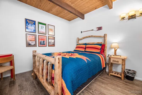 a bedroom with a bed a dresser next to a window