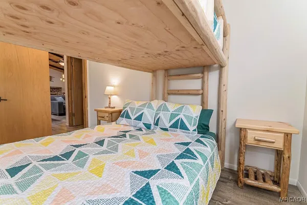a bedroom with a bed and a lamp with wooden floor