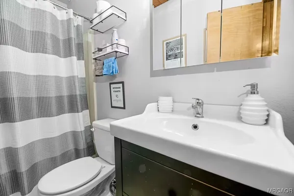 a bathroom with a sink a toilet and shower curtain