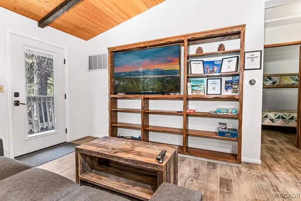 a living room with furniture a flat screen tv and a floor to ceiling window