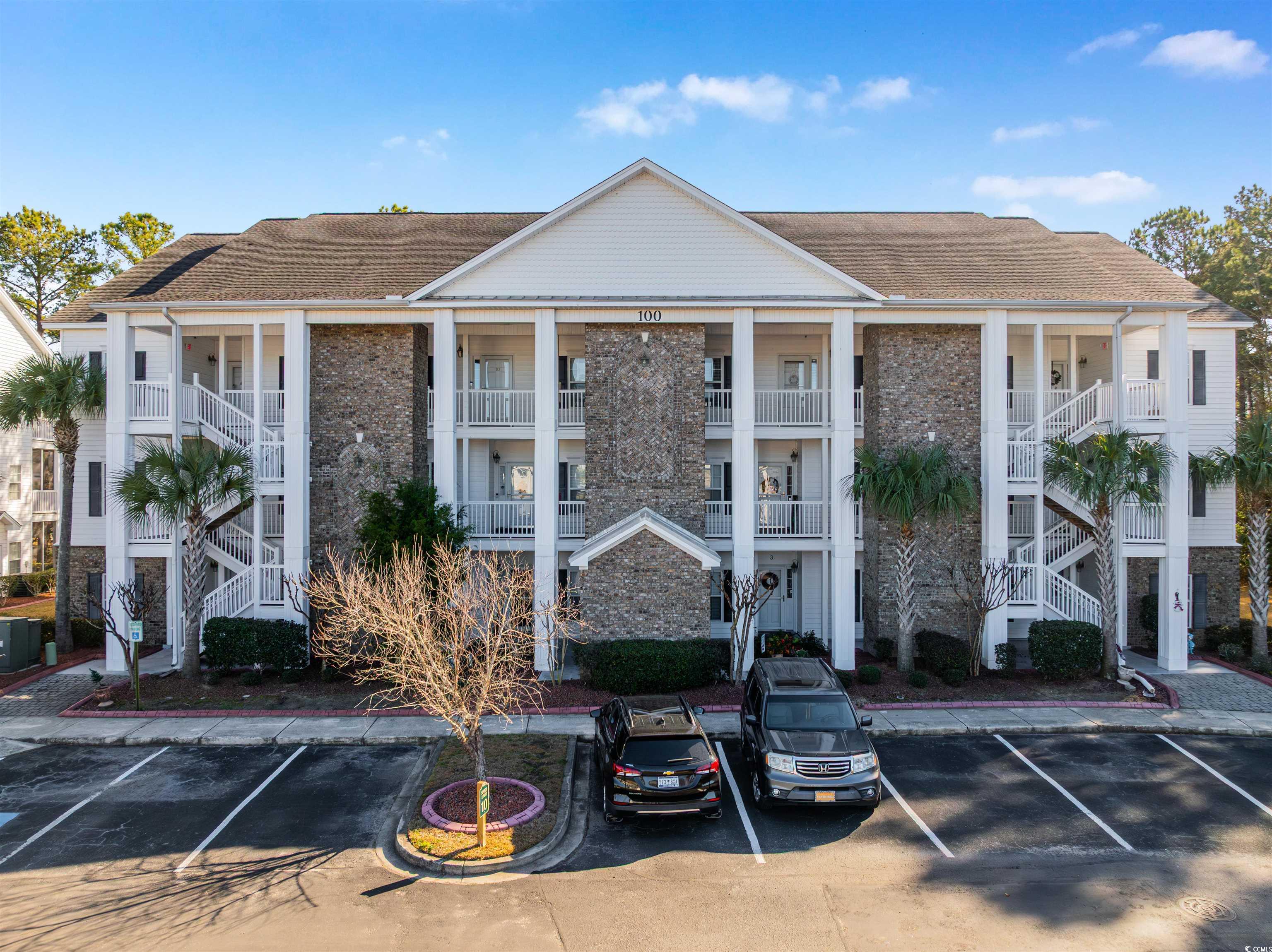View of apartment building / complex with uncovered parking and stairs