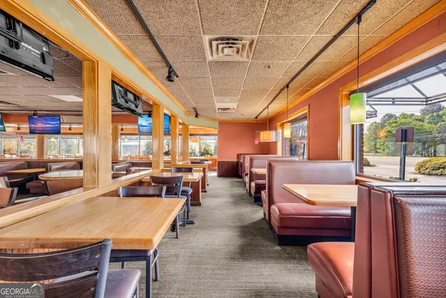 a view of a dining room with furniture next to ceiling window and a rug