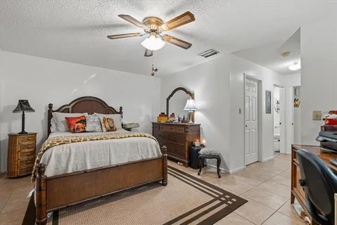 a bedroom with a large bed and a chandelier
