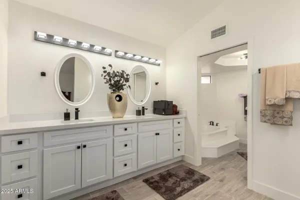 a spacious bathroom with a double vanity sink mirror and toilet