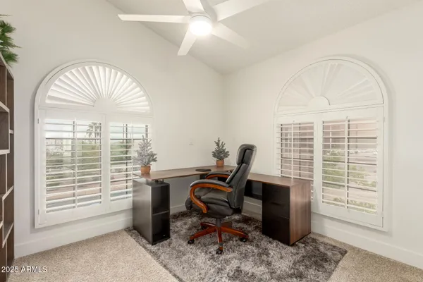 a view of a workspace with furniture and a window