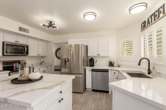 a kitchen with stainless steel appliances a sink a stove top oven a counter space and cabinets