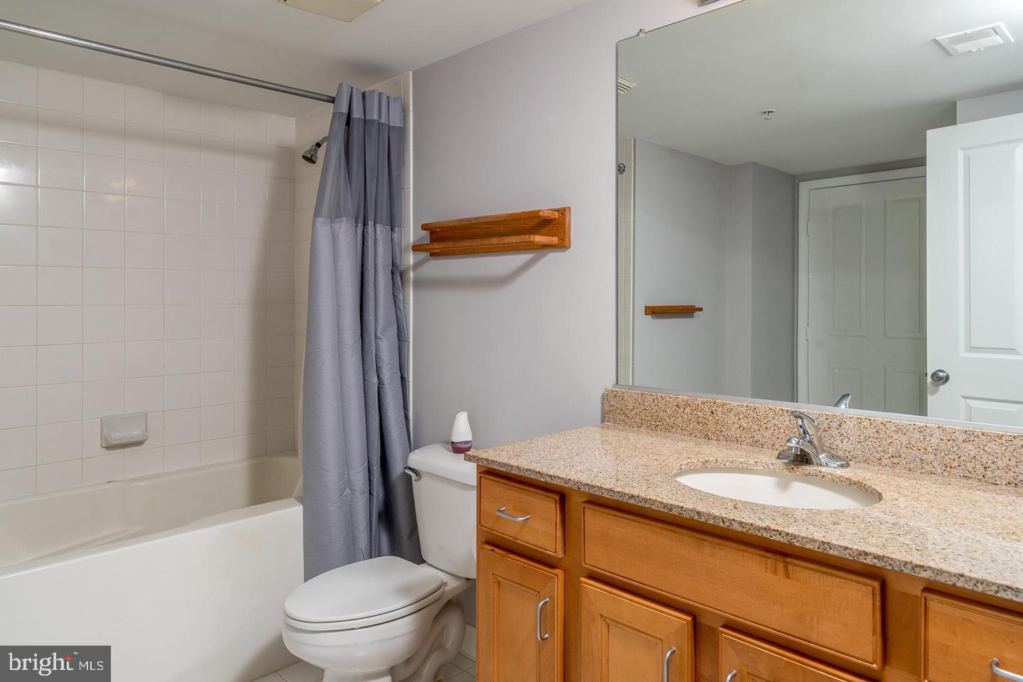 414 Water Street, Unit 2611 Baltimore, MD 21202 - Photo 14 of 23 a bathroom with a granite countertop sink toilet and shower