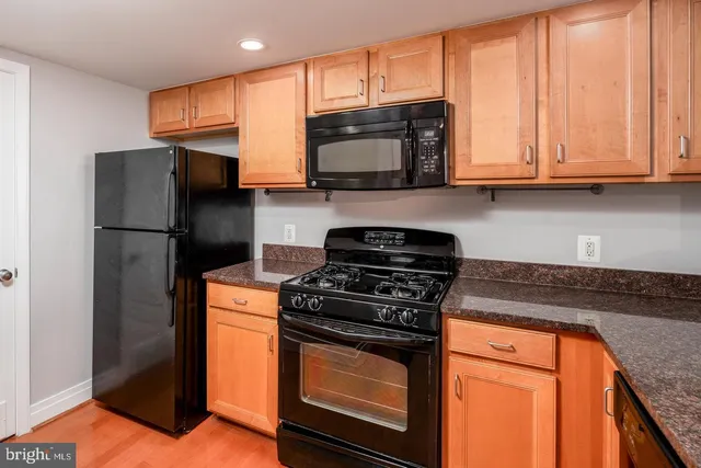 a kitchen with stainless steel appliances granite countertop wooden cabinets a stove top oven a sink and dishwasher