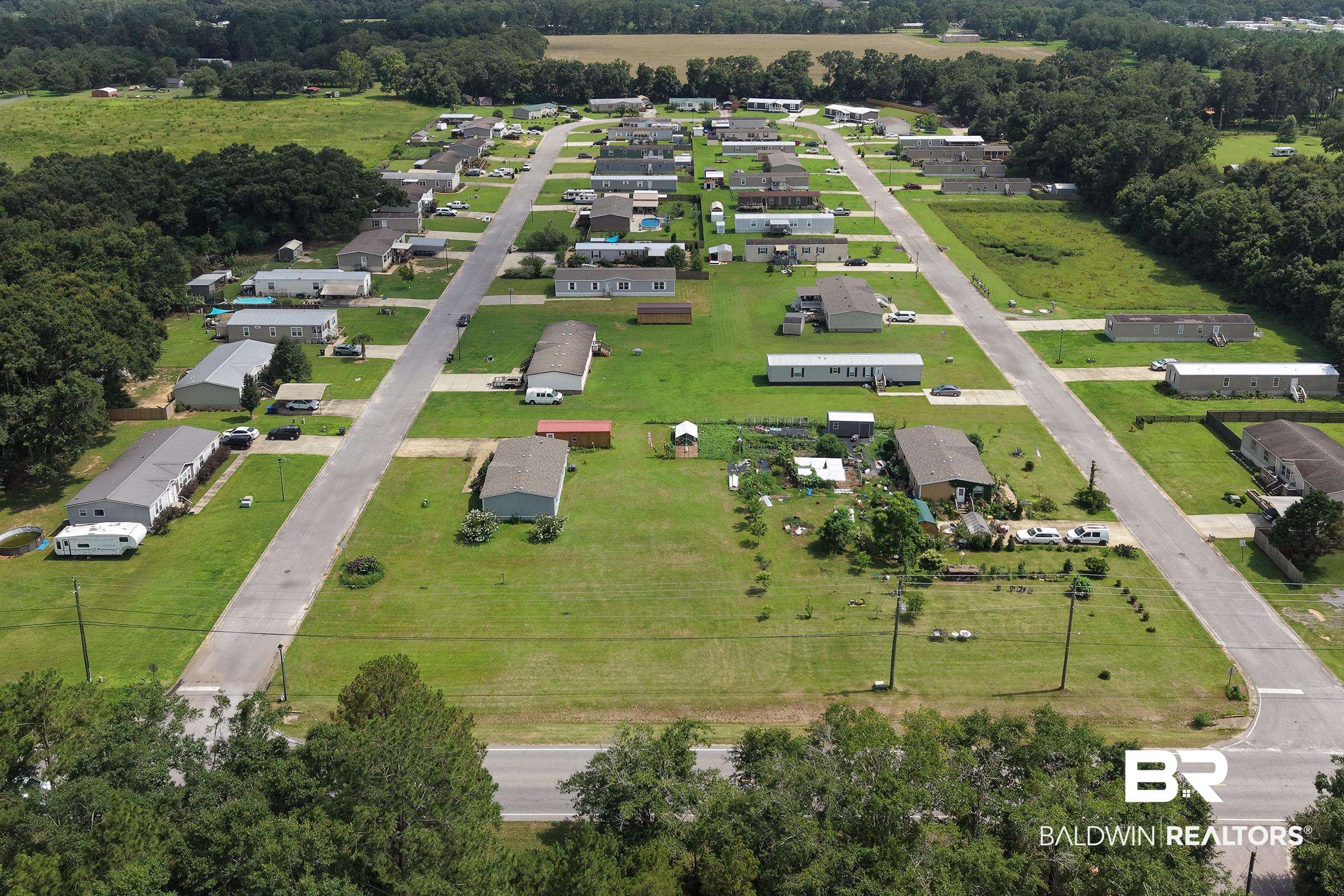 21601 Westside Loop Silverhill, AL 36576 - Photo 4 of 42 Aerial perspective showcasing a residential community with paved roads, individual lots, and surrounding mature trees