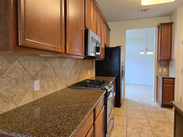 a kitchen with stainless steel appliances granite countertop a refrigerator stove and microwave