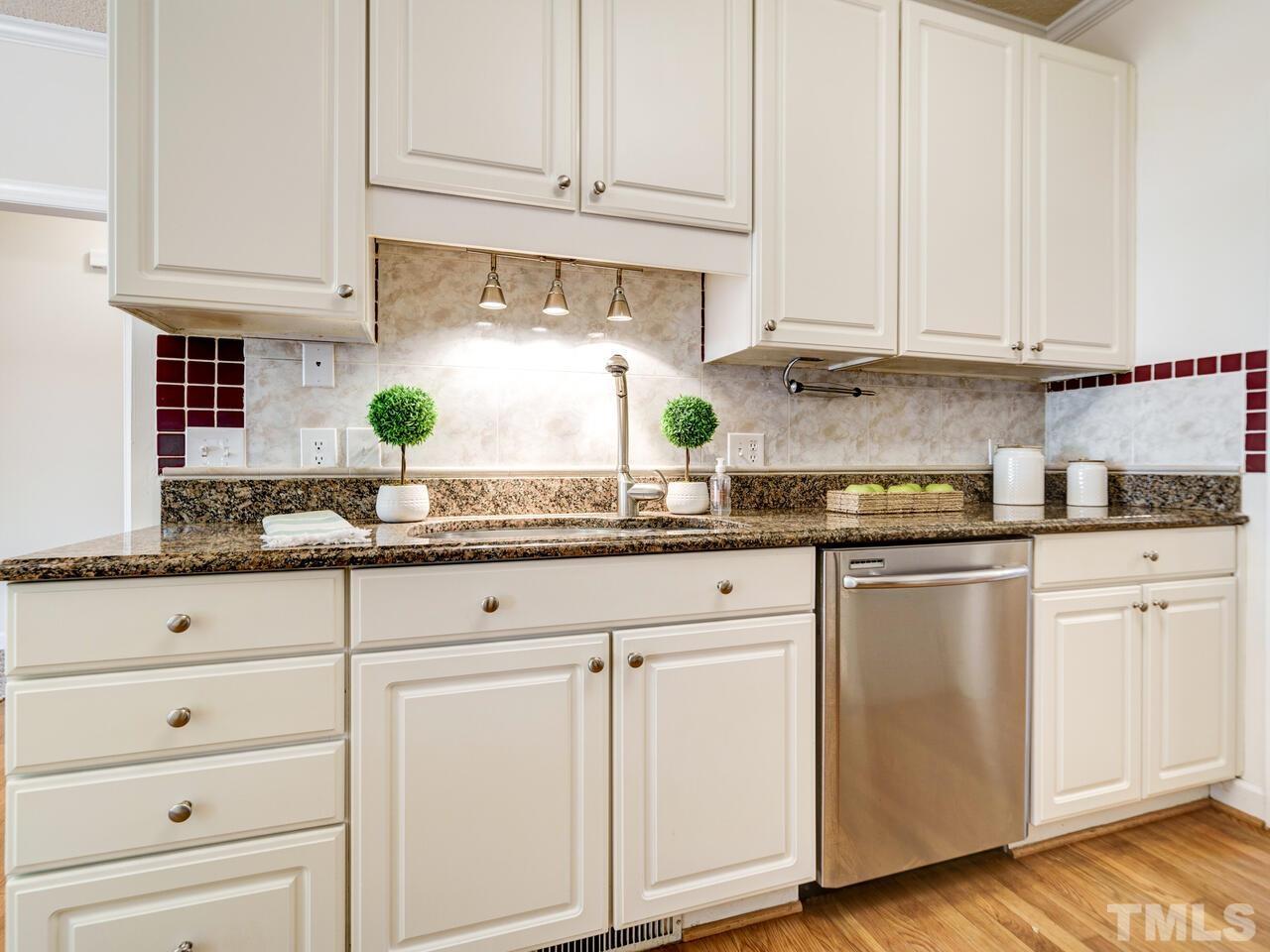 4121 Starboard Court Raleigh, NC 27613 - Photo 17 of 45 a kitchen with granite countertop white cabinets and white appliances