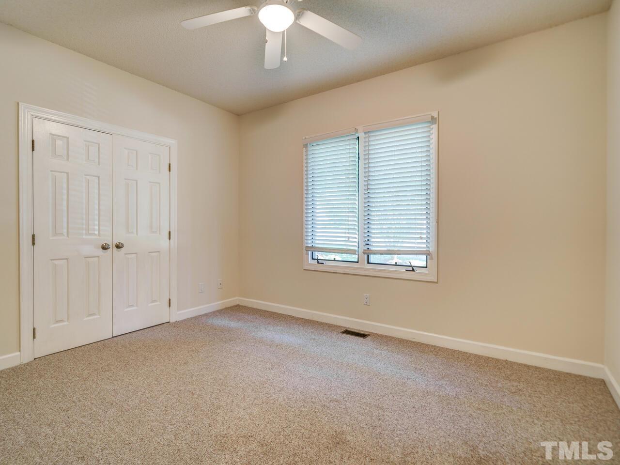 4121 Starboard Court Raleigh, NC 27613 - Photo 24 of 45 an empty room with a chandelier fan and windows