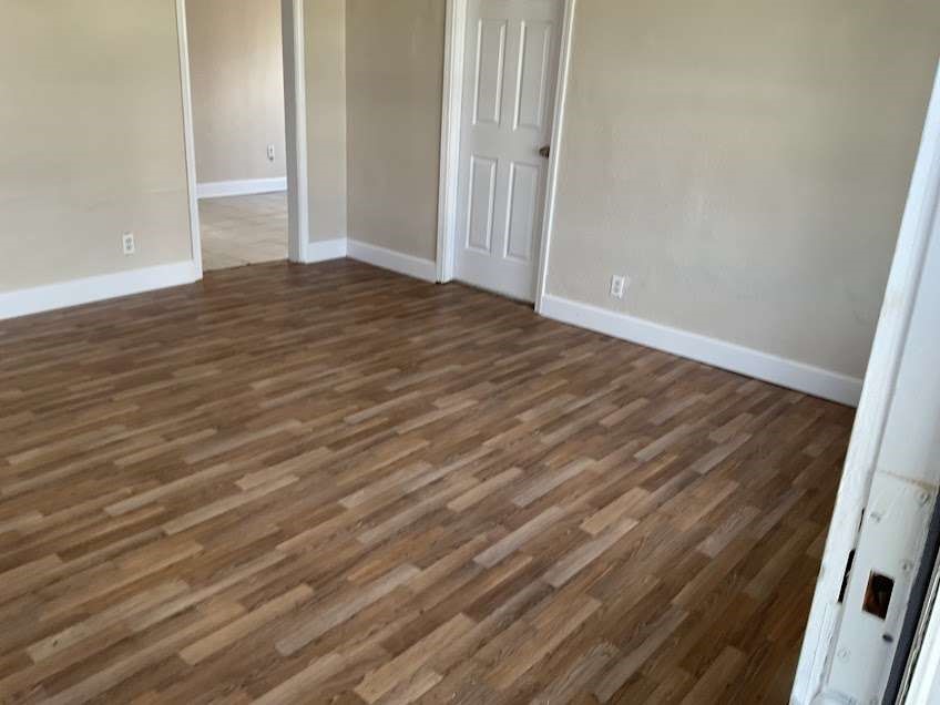 815 West 12th Street Freeport, TX 77541 - Photo 3 of 11 a view of an empty room with wooden floor and a window