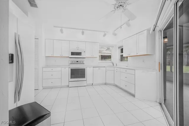 a kitchen with white cabinets and white appliances