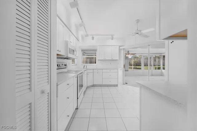 a kitchen with white cabinets and white appliances