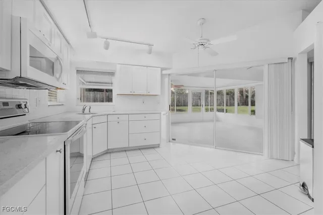 a kitchen with white cabinets and appliances