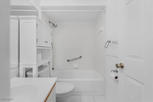 a bathroom with a granite countertop bathtub shower sink vanity and toilet