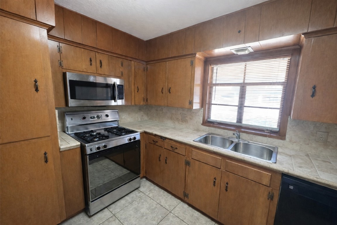 903 Lamonte Lane Houston, TX 77018 - Photo 7 of 36 a kitchen with stainless steel appliances a stove microwave and sink