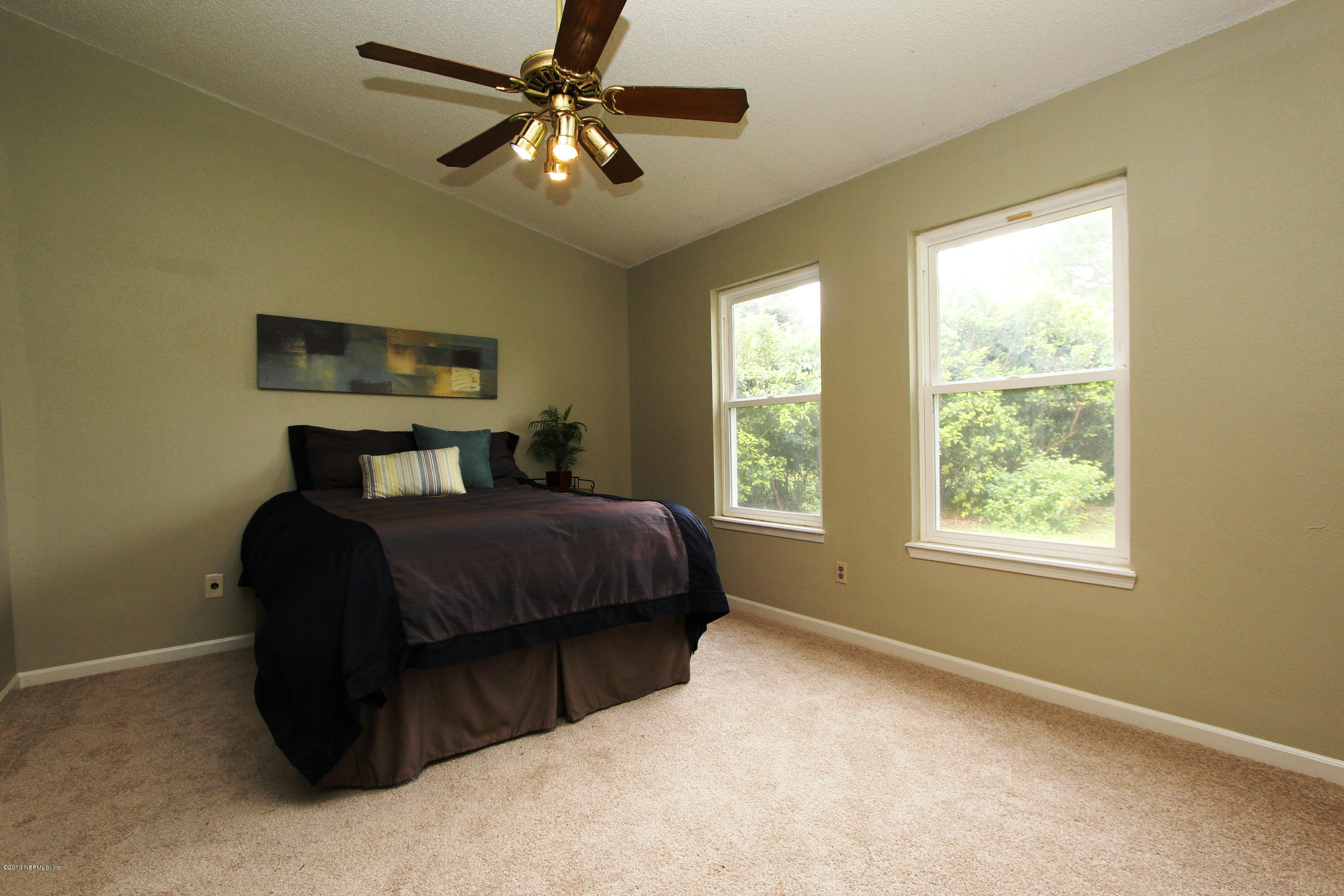 2462 Wattle Tree Road East Jacksonville, FL 32246 - Photo 28 of 35 a bedroom with a bed ceiling fan and a window