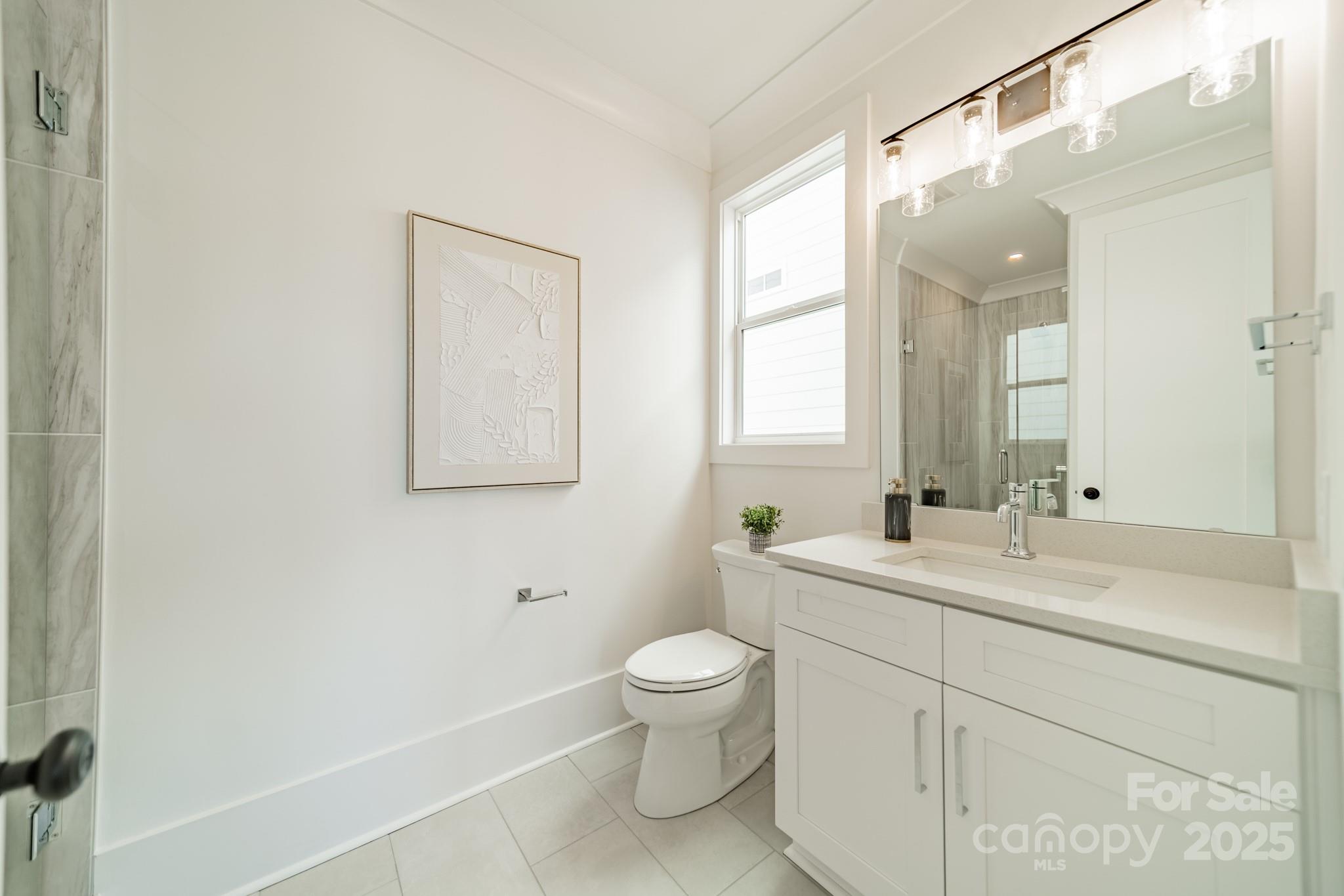 19032 Newburg Hill Road, Unit 23 Davidson, NC 28036 - Photo 31 of 39 a bathroom with a toilet a sink a mirror a vanity and window