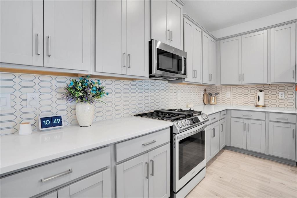 13639 Rangeland Boulevard Odessa, FL 33556 - Photo 11 of 63 a kitchen with stainless steel appliances white cabinets and a stove top oven