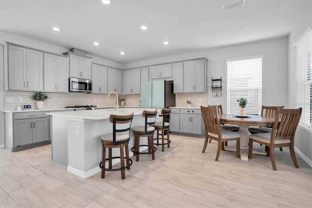 13639 Rangeland Boulevard Odessa, FL 33556 - Photo 13 of 63 a kitchen with a dining table chairs appliances and cabinets