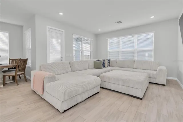 a kitchen with stainless steel appliances a stove a sink a microwave a refrigerator and white cabinets