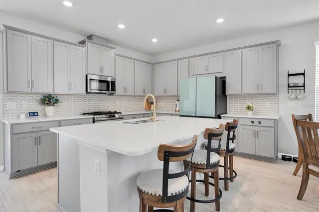 a kitchen with a sink window and chairs
