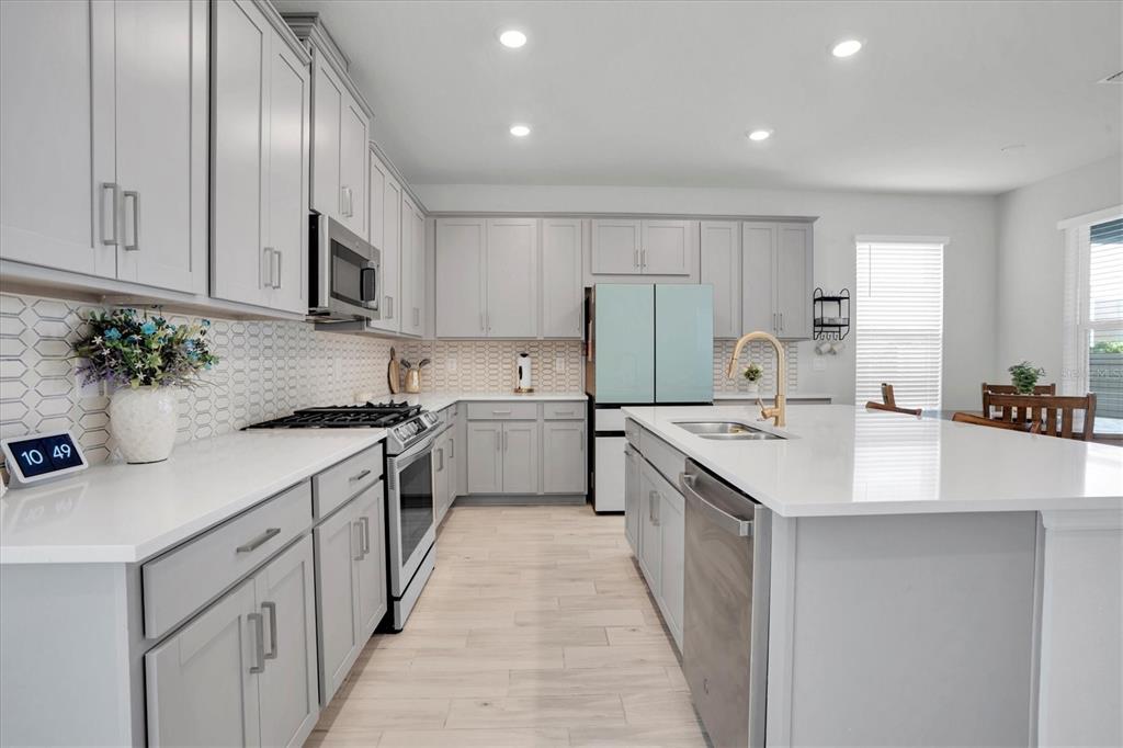 13639 Rangeland Boulevard Odessa, FL 33556 - Photo 10 of 63 a kitchen with stainless steel appliances kitchen island granite countertop a sink a stove and cabinets