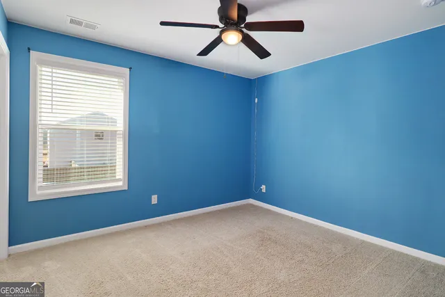 an empty room with a window and a fan