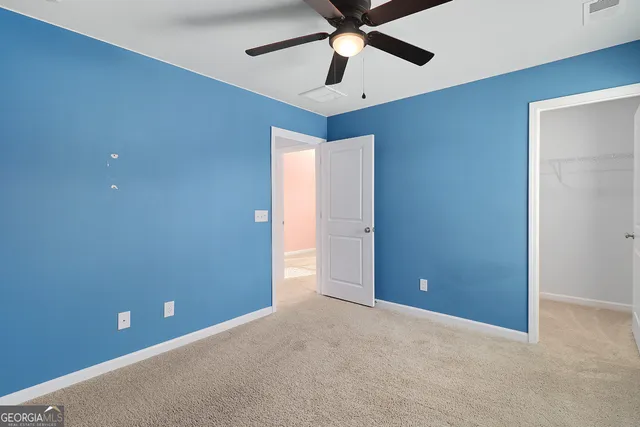 an empty room with chandelier fan
