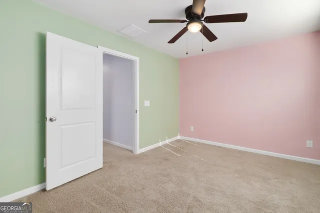 an empty room with chandelier fan