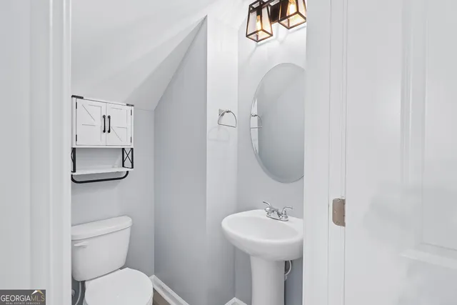 a bathroom with a toilet sink and mirror