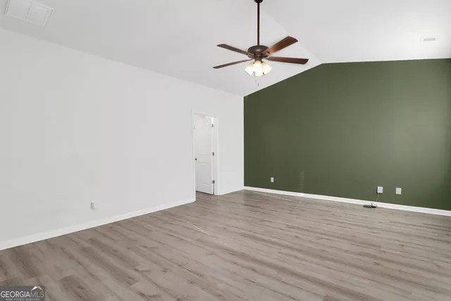 a view of an empty room with wooden floor