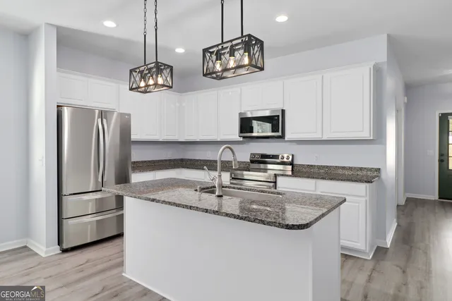 a kitchen with stainless steel appliances granite countertop a sink refrigerator and microwave