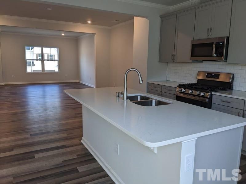205 Nahunta Drive Apex, NC 27539 - Photo 4 of 24 a kitchen with kitchen island a sink stainless steel appliances and cabinets