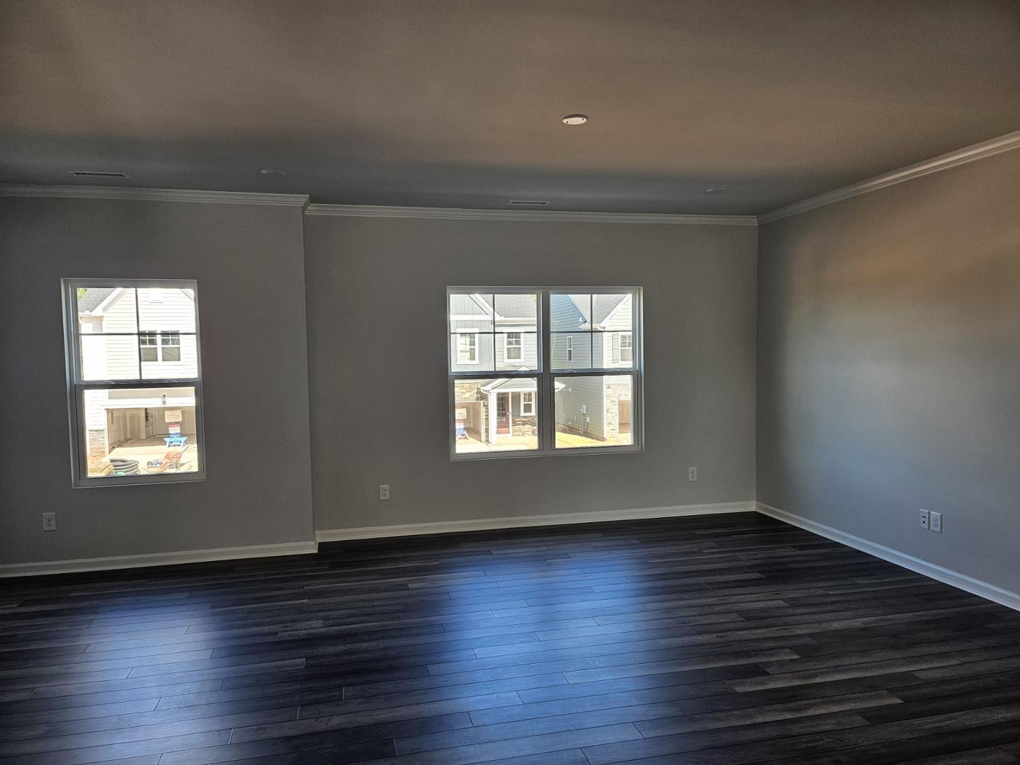 205 Nahunta Drive Apex, NC 27539 - Photo 6 of 24 an empty room with wooden floor and windows